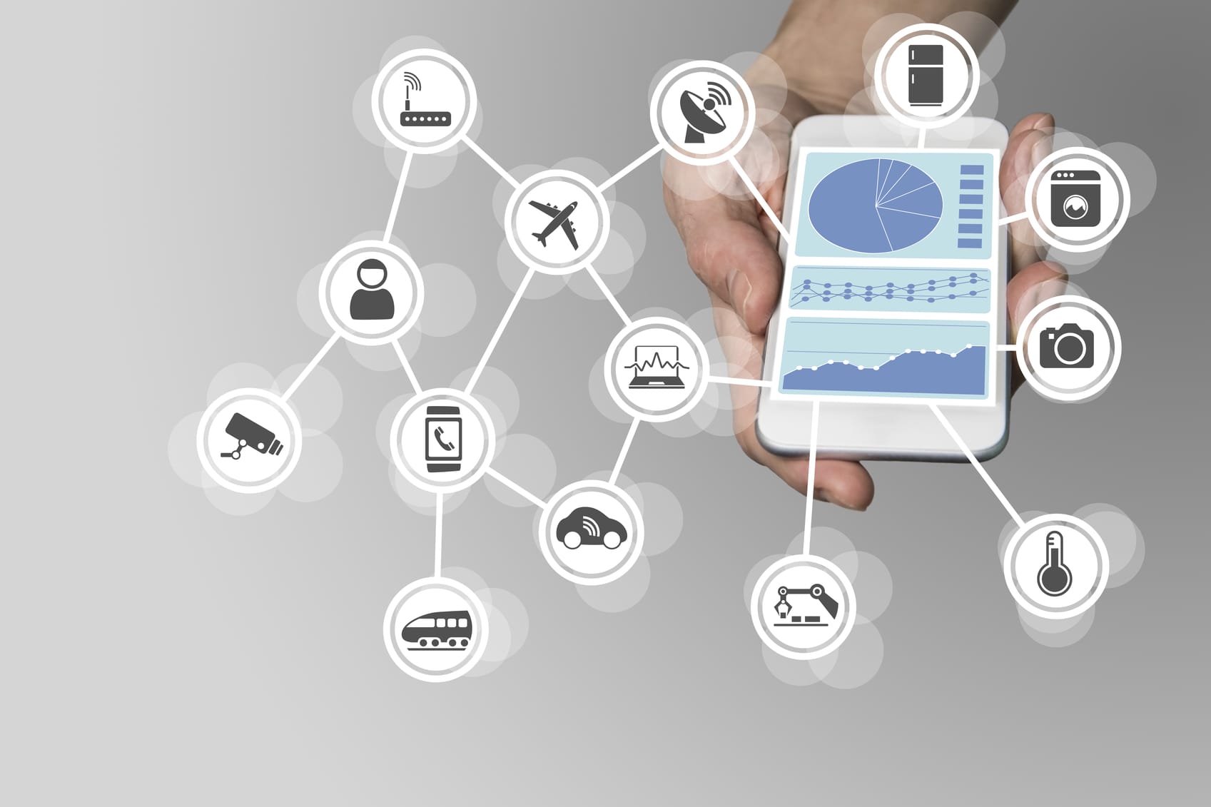 Hand holding modern smart phone on neutral background. Dashboard in order to monitor and control internet of things network of devices