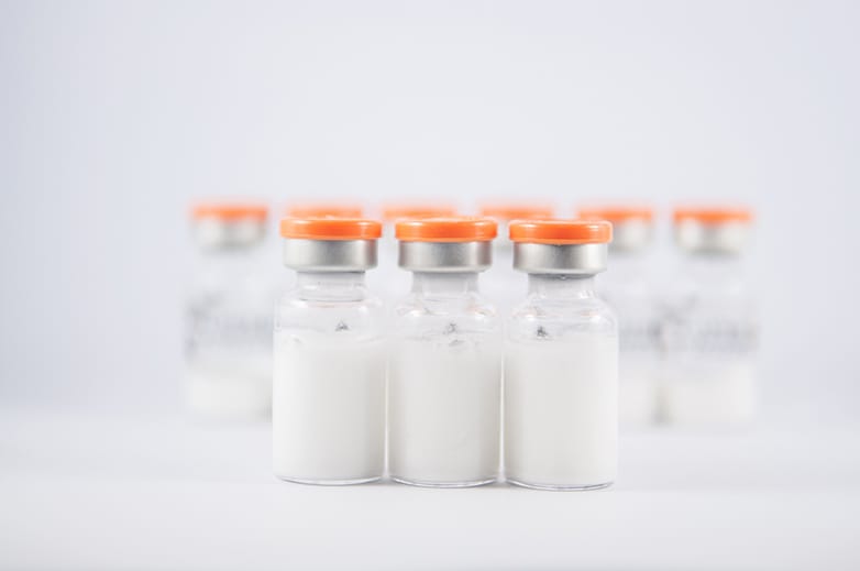 Orange cap injection vials show medicine concept